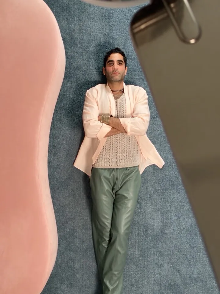 Lying on a blue rug in a cream jacket, overhead shot